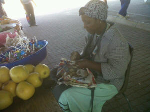 Lady at taxi rank preparing small bags of clay.